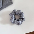 Détail rapproché d'un chouchou en satin gris argenté avec texture verticale et couture fine - Petit / Gris
