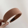 Close-up of camel wool headband featuring a handmade label and soft felt texture - Camel