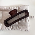 Detail view of large dark brown wood texture hair claw clip on beige quilted mat - 6# Dark Color - Rectangular