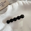 Détail d'une pince à cheveux avec perles en résine noire et lettrage doré fait main - Noir