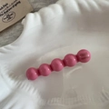 Détail d'une pince à cheveux à perles roses en acétate sur un plateau en coquillage blanc - Rose