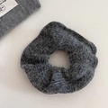 Detailed texture of a soft dark grey mohair knitted scrunchie for winter hair styling - Gray