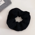 Detail shot of black knitted hair scrunchie with soft wool texture and elastic design - Black