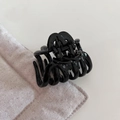 Close-up of a glossy black small hair claw clip with cross-teeth design and metal spring - Glossy Black Small Claw