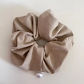 Detailed texture of light brown corduroy scrunchie with a white pearl pendant decoration - Apricot