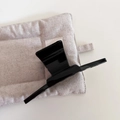 Detail view of large glossy black claw clip showing strong metal spring and smooth texture - Bright Black