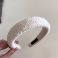 Vista detallada de una diadema de felpa crema con esponja gruesa y tejido tipo boucle - Blanco Roto
