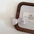 Détail d'une barrette à nœud blanc nacré avec texte France Handmade sur plateau en bois - Blanc Sirène