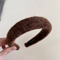 Close-up of dark brown wool headband texture with fluffy velvet finish and inner brand label - Coffee
