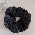 Detailed top view of a large black satin scrunchie with layered French ruffle pleats - Black