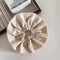 Detailed close-up of cream knit fabric scrunchie with delicate scalloped edge - Off-white