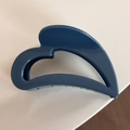 Detailed macro view of the blue heart-shaped cutout hair claw clip with a glossy finish - Blue