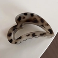 Détail d'une pince à cheveux en forme de cœur à motif écaille sur fond épuré - Écaille de Tortue Claire