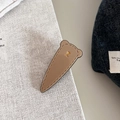 Detail der Haarklammer mit Bärenohr-Design und goldenem Emblem auf Denim - Khaki