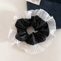 Detail van zwarte faux lederen scrunchie met witte geplooide organza randen - Zwart