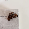Detail of tortoise shell acetate hair claw clip with golden spring on woven texture - Wavy M-Shape Claw / Coffee Leopard