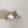 Dettaglio macro del fermaglio a fiocco in velluto grigio con decorazione di perle eleganti - Bianco Sporco