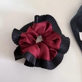 Detail van bordeauxrode satijnen scrunchie met elegante zwarte geplooide randen - Rood