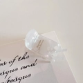 Detail showing high-quality acetate hair claw with elegant golden French lettering - Mermaid White