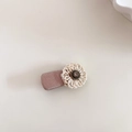 Detalle de horquilla de flor con perlas artesanales sobre base de tela rosa y cristal - Champaña