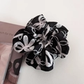 Dettaglio di elegante elastico per capelli in pizzo nero con ricamo floreale bianco - Stile di base / Nero