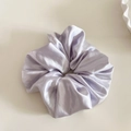 Detailed view of large lavender satin scrunchie with elegant silk texture and soft folds - Purple