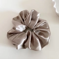 Detailed view of champagne gold satin scrunchie with soft pleats and elegant silk texture - Champagne