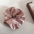Pink satin scrunchie with pearl accent and silk texture for elegant hairstyles - Pink