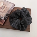 Primer plano de coletero grande de malla con lunares blancos y negros sobre madera - Negro