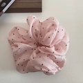 Détail du chouchou à pois roses en mousseline douce pour des coiffures élégantes - Rose