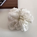 Détail du chouchou en organza blanc à pois noirs avec texture multicouche pour chignons - Blanc