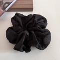 Vue détaillée du chouchou noir à pois avec texture de tissu en tulle doux et plissé - Noir