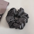 Détail d'un chouchou à rayures noires et blanches avec points argentés et texture plissée - Noir