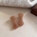 Makroaufnahme von zwei handgefertigten braunen Acetat-Haarclips mit goldener Gravur - Milchkaffee