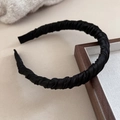 Detalle de diadema de satén plisado negro con textura de seda y acabado elegante - Negro