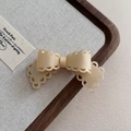 Close-up of cream acetate bow hair clip with hollow lace edges on a display tray - 5# Apricot Hair Clip