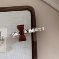 Vue rapprochée d'une barrette en cristal avec nœud marron sur plateau bois - Amber Bow Style / Café Foncé
