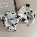 Detalle de lazo grande para el pelo con estampado de rosas negras en tejido de gasa - Estilo Blanco con Flores Pequeñas