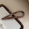 Detail der Acetat U-Haarnadel mit Marmormuster auf elegantem minimalistischem Holztablett - Kaffeegrün