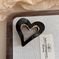 Detail of a black acetate heart hair claw clip with golden metal teeth on a wooden tray - 8# Black