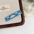 Detalle de pinza de pelo azul de acetato con nubes blancas en bandeja de madera - Azul Cielo