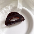 Nahaufnahme einer dunkelbraunen Haarklammer mit goldenem Barrette La France Schriftzug - Kaffee/Braun