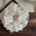 Elegante elastico in pizzo beige con motivo floreale su un vassoio di legno raffinato - Scrunchie in Pizzo Grande
