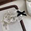 Close-up of beige lace hair clip with pearls and a small black ribbon bow detail - Bow BB Clip