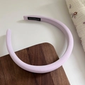 Diadema de tela morada hecha a mano con diseño minimalista fino sobre fondo de madera - Morado