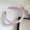 Detail of pink fabric sponge headband with a black handmade label on a white background - Pink Plaid