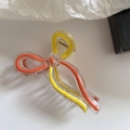 Detail view of transparent bow hair claw clip with orange and yellow interior accents - Orange Yellow Series