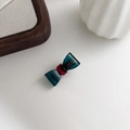 Detail of dark cyan bow hair clip with gold France Handmade logo and red center - Dark Blue