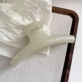 Detalle de una pinza para el pelo verde claro de 13cm sobre una bandeja de madera - Verde