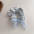 Scrunchie in pizzo a righe blu con fiocco su sfondo pulito e minimalista - Fiocco in Pizzo Blu